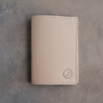 Gray Sand leather passport cover with the initial J in a circle pressed into the bottom corner