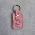 Parisian Blossom pink leather keychain with a debossed Great Dane and the words Dane MOM on gray concrete