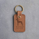 Caramel leather keychain debossed with a tall Great Dane above Best friend and THE DANE, on gray concrete