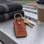 Orange tan Halftime Orange Slices keychain on keys next to a cooler and a bowl of orange slices on a sideline