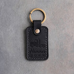 Black leather keychain debossed with a semi truck tractor above Hammer and DOWN