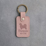 Blush pink leather keychain with a debossed Havanese and the words Havanese MOM on gray concrete