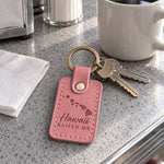 Pink Hawaii Raised Me keychain on apartment keys beside a plumeria lei on a mainland kitchen counter