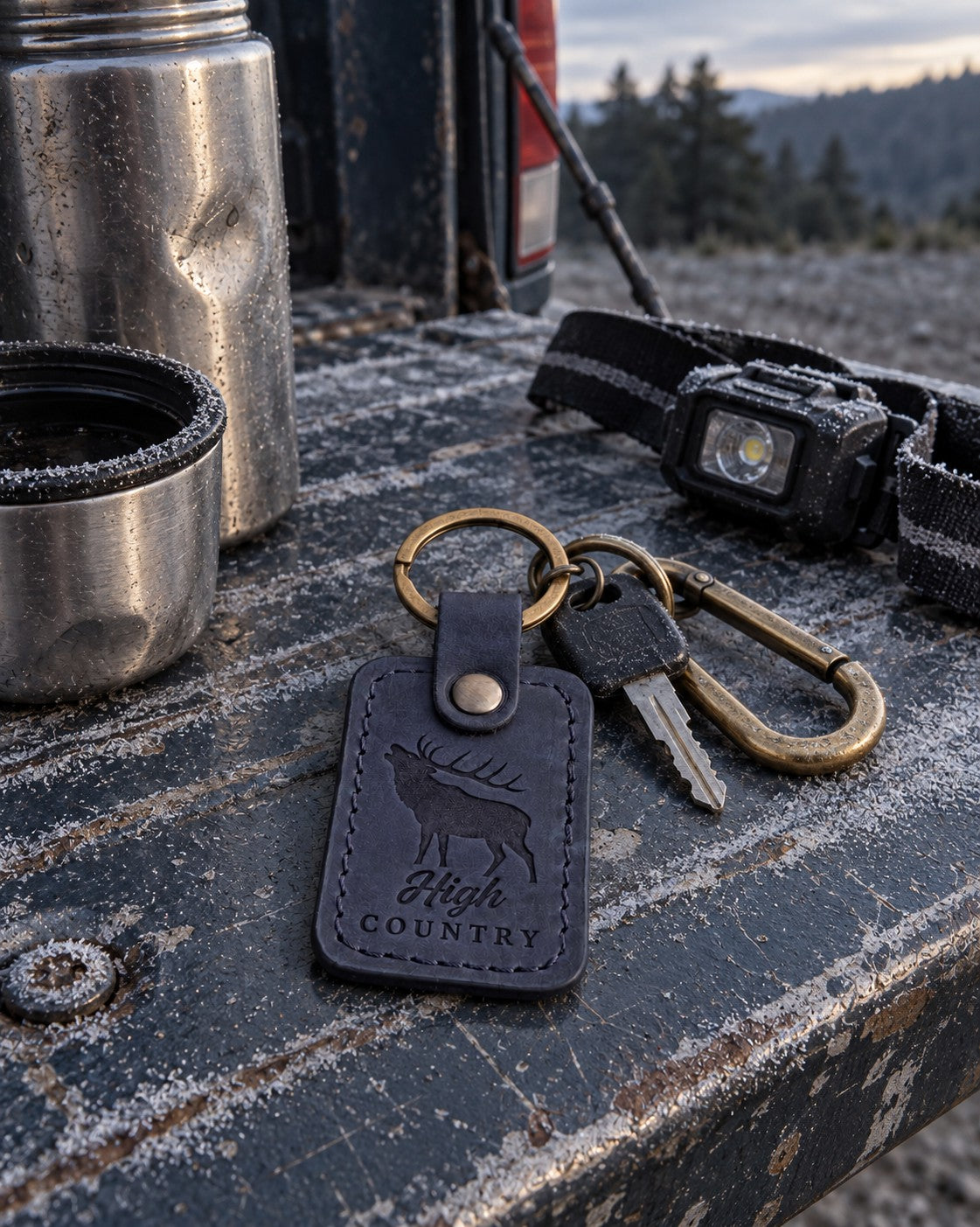 Navy High Country keychain clipped to a frame pack resting on a granite ledge above timberline