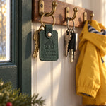 Green Home for CHRISTMAS keychain on house keys hanging beside a wreath on a front door