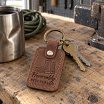 Brown Honorably Discharged keychain on a key ring resting on a pair of polished boots by a front door