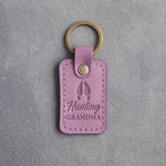 Lilac leather keychain debossed with a whitetail deer track above the words Hunting GRANDMA, on gray plaster