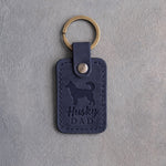 Blueberry navy leather keychain debossed with a Siberian Husky silhouette and the words Husky DAD, on gray concrete