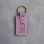 Lilac leather keychain debossed with an Italian Greyhound silhouette and the words Iggy MOM, on gray concrete