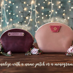Two round makeup bags in sangria and blush showing name-patch and monogram-patch options