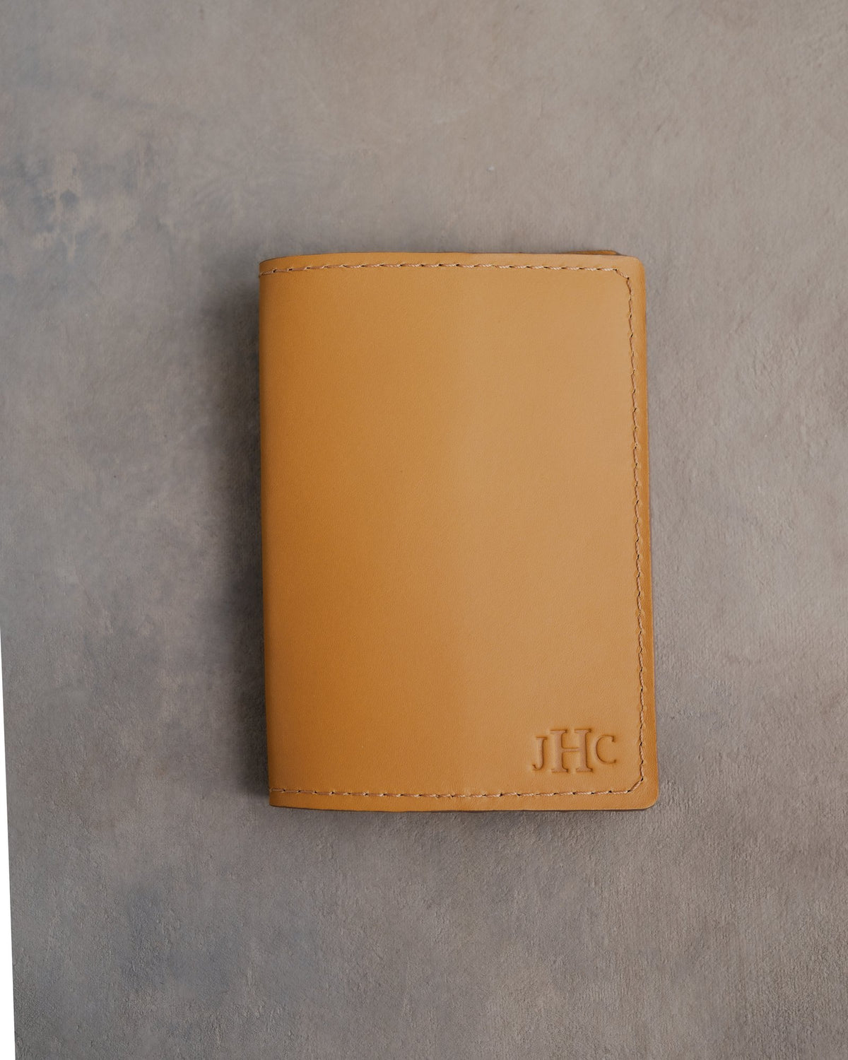 Indian Summer leather passport cover with the monogram JHC with the last initial large pressed into the bottom corner