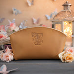 Indian summer initial makeup pouch with a floral monogram, staged among pale roses on a slate table