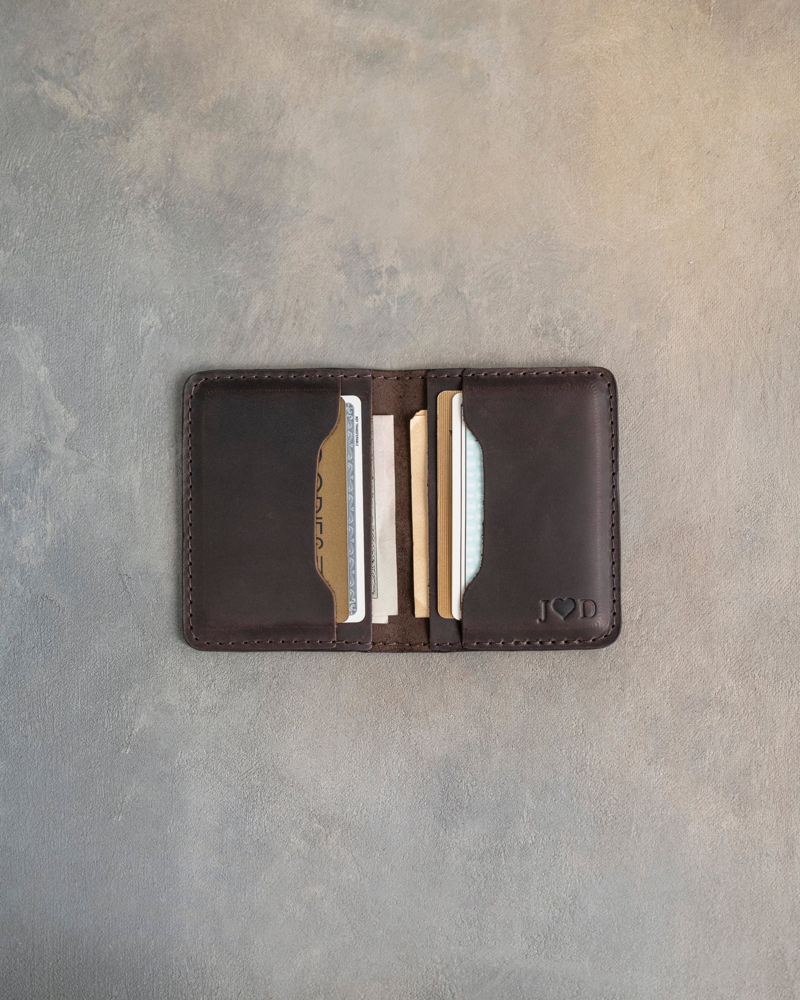 Open leather card wallet showing the card slots and cash pocket