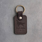 Dark espresso leather keychain debossed with an Irish Setter silhouette and the words Irish Setter DAD, on gray concrete