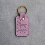 Lilac leather keychain debossed with an Irish Setter silhouette and the words Irish Setter MOM, on gray concrete