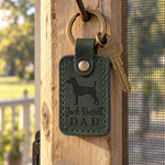Green Jack Russell Dad keychain on a garden gate latch in bright afternoon light