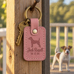 Pink Jack Russell Mom keychain beside a basket of tennis balls on a sunny porch