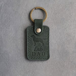 Forest green leather keychain debossed with a Labrador Retriever silhouette and the words Lab DAD, on gray concrete