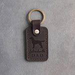 Dark espresso leather keychain debossed with a Labradoodle silhouette and the words Labradoodle DAD, on gray concrete