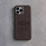 Back of a dark espresso leather iPhone case debossed with a largemouth bass above Dale and LARGEMOUTH below the camera, on gray plaster