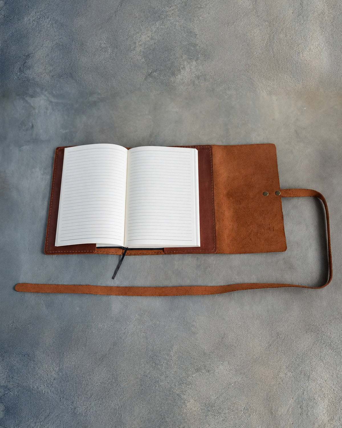 Open leather wrap journal with a lined refillable insert and its long strap