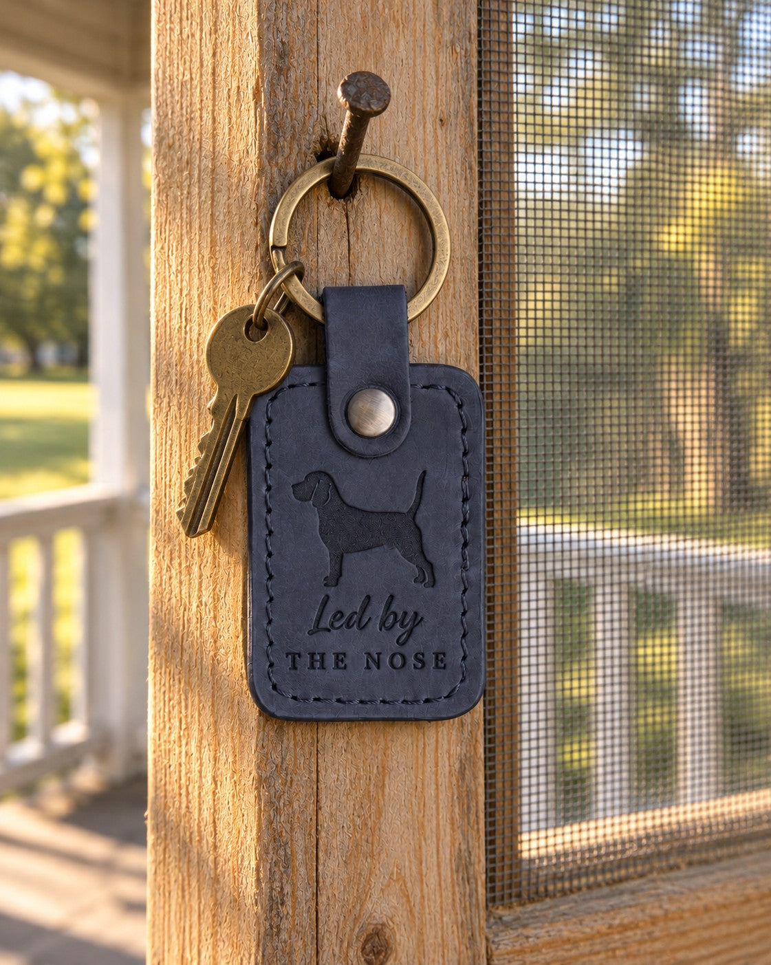 Blueberry navy Led by the Nose leather keychain placed in a warm everyday setting