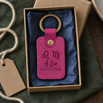 Fuchsia Leo Loves Virgo keychain beside a box of chocolates and a red envelope on a cafe table
