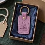 Lilac Libra keychain on a key ring beside an open book on a cafe table in soft autumn light