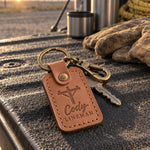 Cody Lineman keychain in caramel leather on bucket truck keys resting on a pair of leather climbing gloves