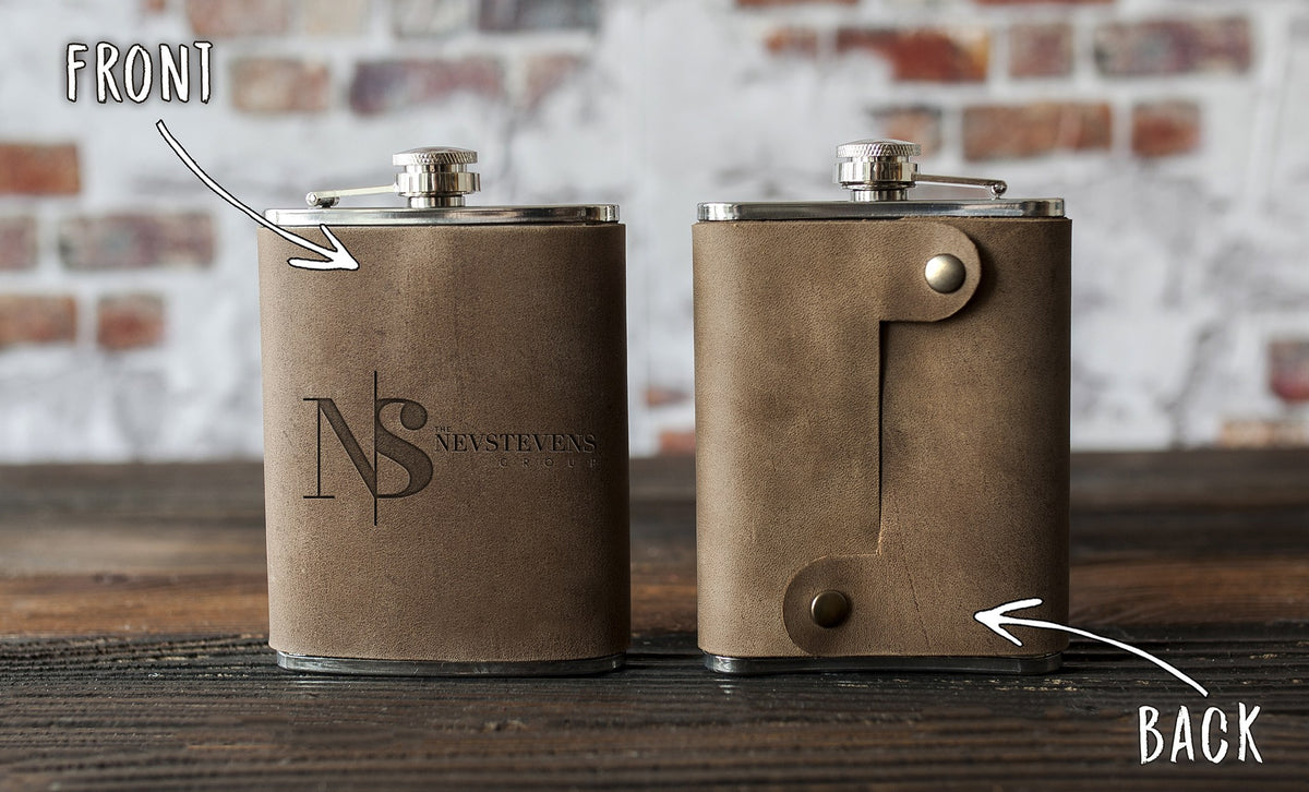 A real logo order: front and back of a leather hip flask with a company monogram pressed in and the snap strap on the back
