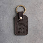 Dark espresso leather keychain debossed with a Belgian Malinois silhouette and Mal DAD on gray concrete