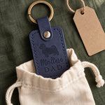 Blueberry navy Maltese Dad leather keychain held in a warm everyday setting