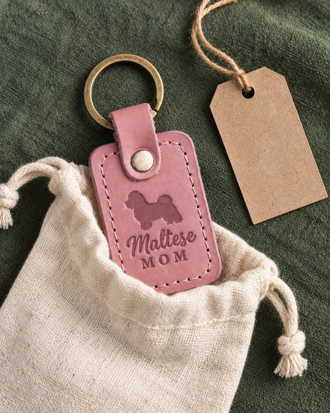 Parisian Blossom pink Maltese Mom leather keychain placed in a warm everyday setting