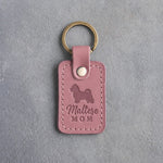 Parisian Blossom pink leather keychain debossed with a Maltese silhouette and the words Maltese MOM, on gray concrete