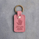Parisian Blossom pink leather keychain debossed with a small hand inside a large hand above Love you and MOM, on gray concrete