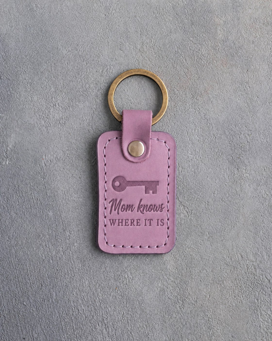 Lilac leather keychain debossed with an old house key below Mom knows and WHERE IT IS