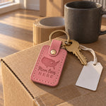 Pink Mom Lives Here keychain on a kitchen key hook beside a framed family photo