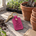 Fuchsia Mom's Garden keychain beside a bunch of pink tulips wrapped in brown paper on a kitchen counter