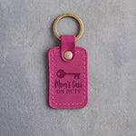 Fuchsia leather keychain debossed with an old key below Mom's taxi and ON DUTY