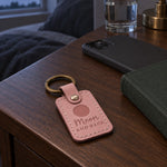 Pink Moon and Back keychain resting on a folded baby blanket beside a set of car keys in soft morning light
