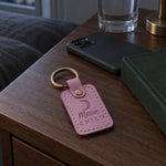 Lilac Moon Child keychain on a ring of house keys beside a candle on a nightstand in evening light