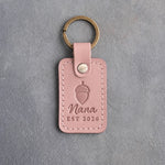 Blush pink leather keychain debossed with a single acorn above Nana and EST 2026