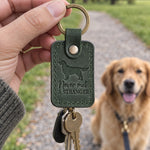 Green Never Met a Stranger keychain held in a park while a smiling golden retriever sits on a leash behind