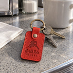 Red North Pole Alaska keychain peeking out of a Christmas stocking beside a handwritten letter to Santa