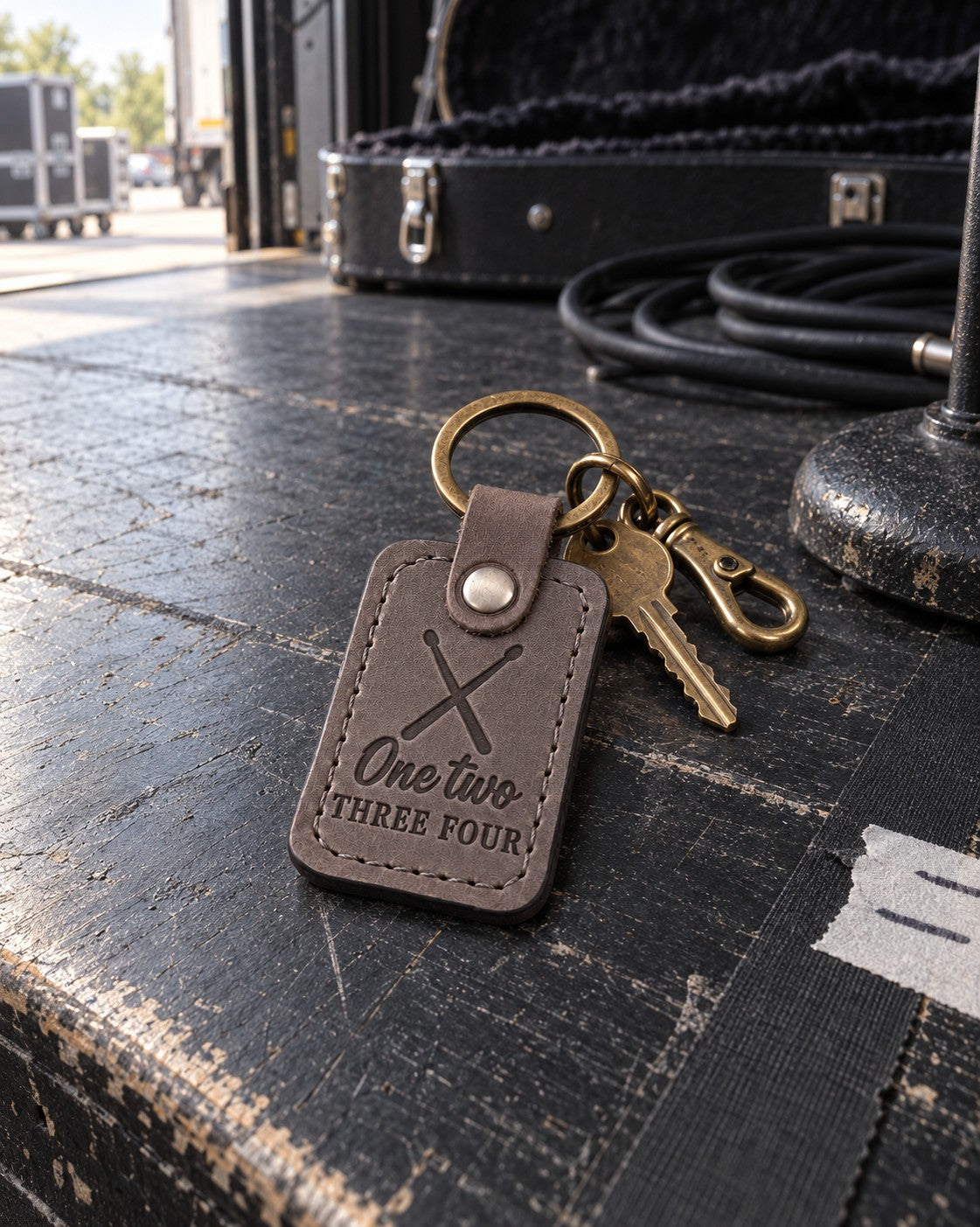 One Two Three Four keychain in gray leather on a car key resting on a drum throne