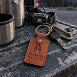 Opening Day keychain in tan leather on truck keys beside a steel thermos on a dashboard before dawn