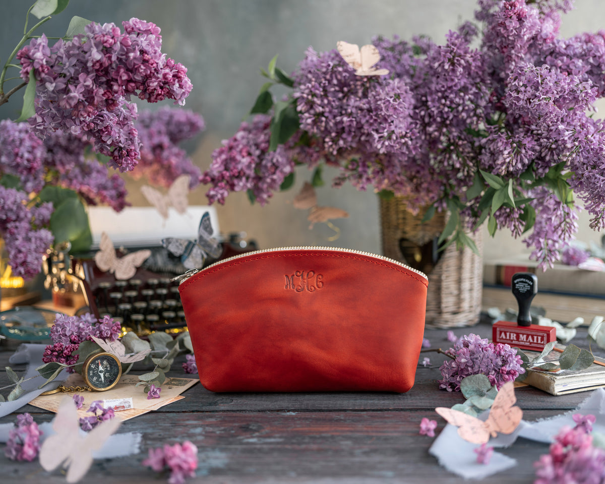 Makeup bag in poppy red leather with a small embossed monogram