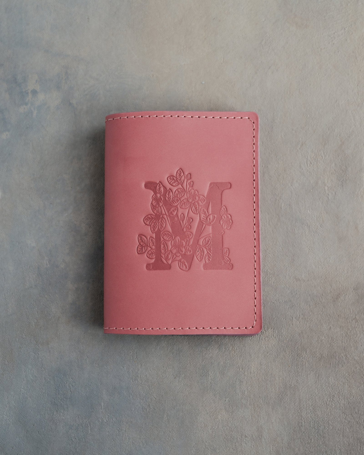 Parisian Blossom leather passport cover with a large floral initial M pressed into the front