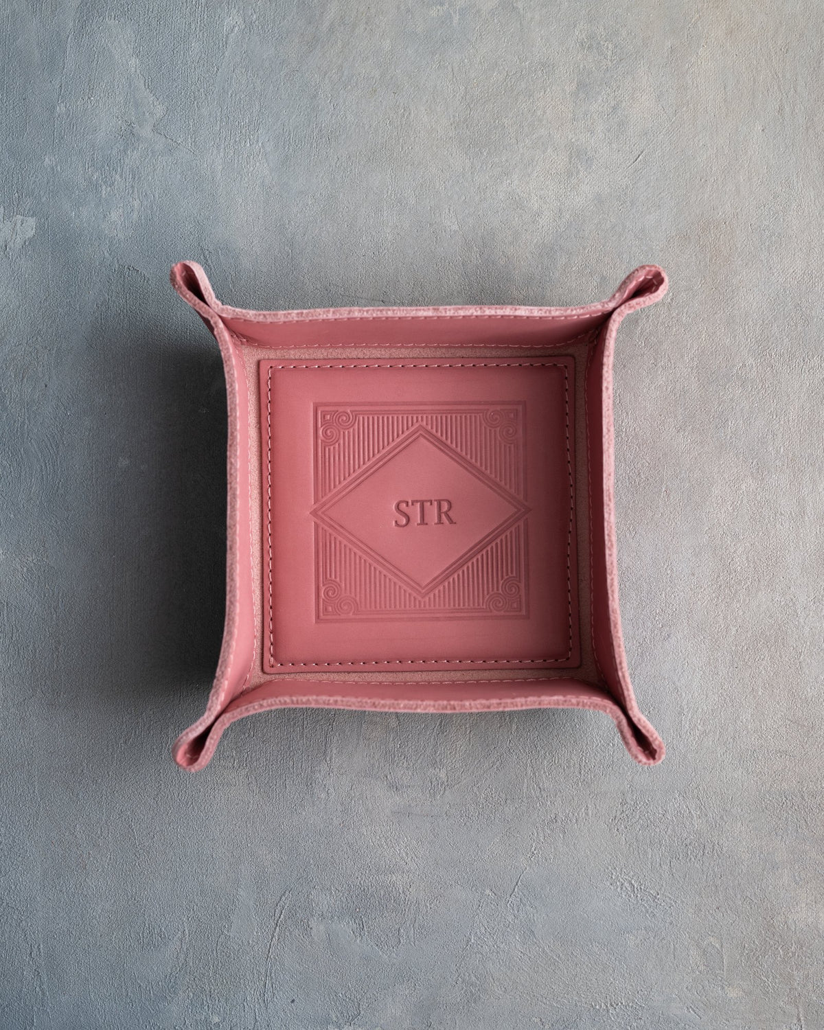 Parisian Blossom leather valet tray with snapped corners and the initials STR pressed into the diamond frame, seen from above