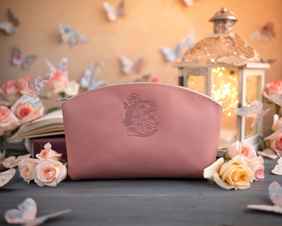 Parisian blossom leather makeup bag with a floral monogram deboss, roses and a lit lantern in the background